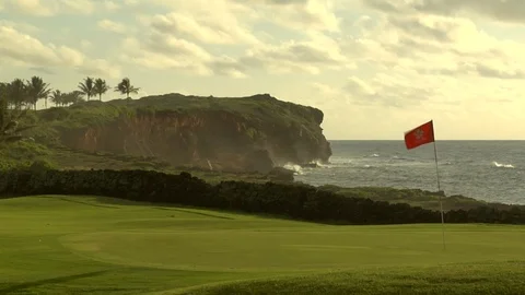 Ocean waves crash onto cliff behind golf course putting green C Stock Footage 125336531