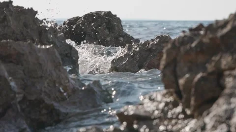 Ocean waves crash powerfully between dark rugged coastal rock formations Stock Footage 337409042