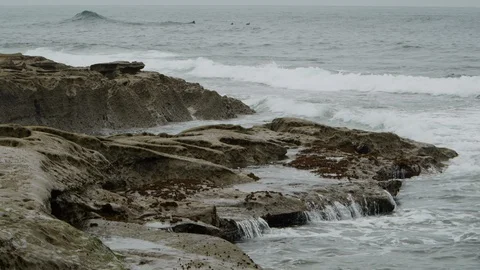 Ocean waves crash into rocks on a cloudy day Vídeo Stock 119041675