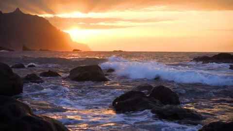 Ocean waves crash on rocks in sunset light Playa Benijo beach, Tenerife, Canary Stock Footage 136956139