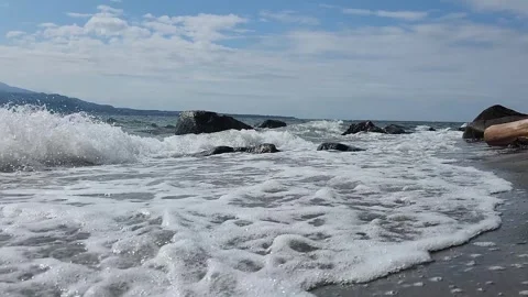 Ocean waves crash onto sandy beach 스톡 동영상 337697055