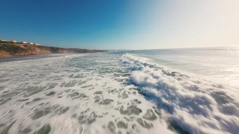 Ocean waves crash onto sandy shore with white foam Stock Footage 339786286