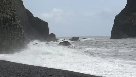 Ocean Waves Crashing Against Basalt Rock Formations at Reynisfjara Beach in Stock Footage 339958078