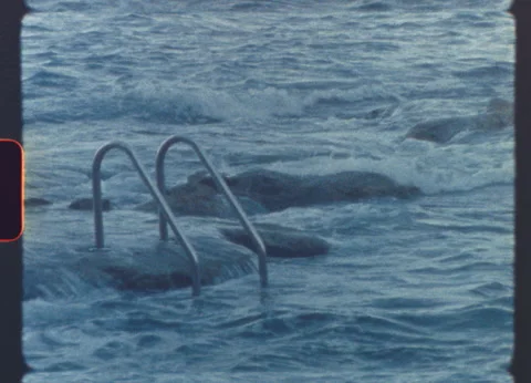 Ocean waves crashing against coastal ladder in vintage film look Stock Footage 319829111