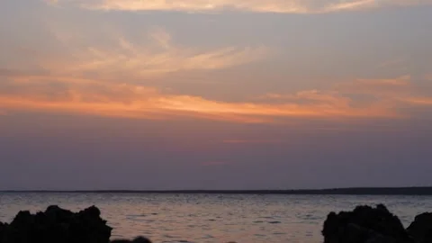 Ocean Waves Crashing Against Distant Rocks at Sunset Stock Footage 305957877