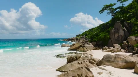 Ocean waves crashing against granite rocks. La Digue, Seychelles. Stock Footage 303634288