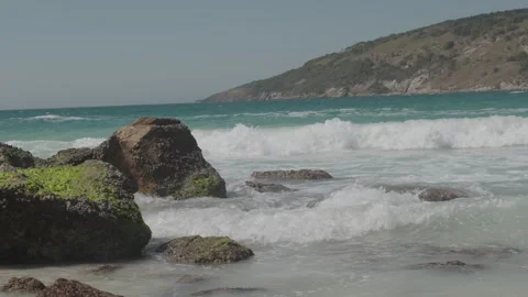 Ocean waves crashing against moss covered rocks on the shoreline 動画素材 342572475