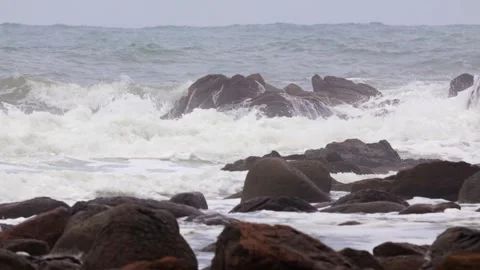 Ocean waves crashing against rugged rocky coastline in stormy weather. Stock Footage 337684388