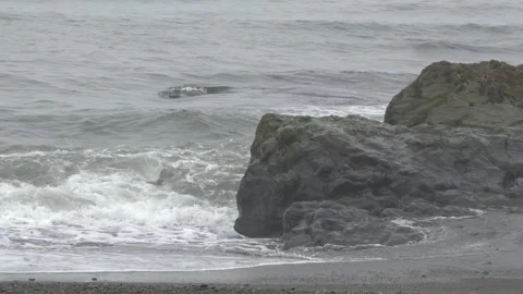 Ocean waves crashing against volcanic rock on an Icelandic beach 4K footage Stock Footage 339922889