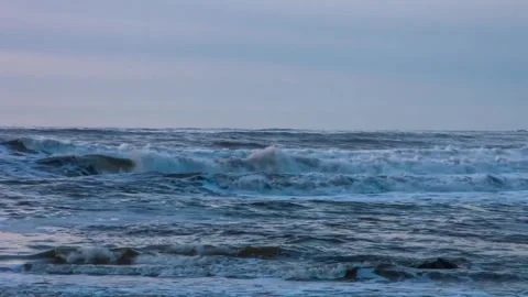 Ocean waves crashing and rolling under an overcast sky wide shot Stock Footage 342139043