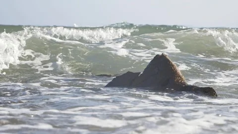Ocean waves crashing around a jagged rock in the sea. Stock Footage 337408489