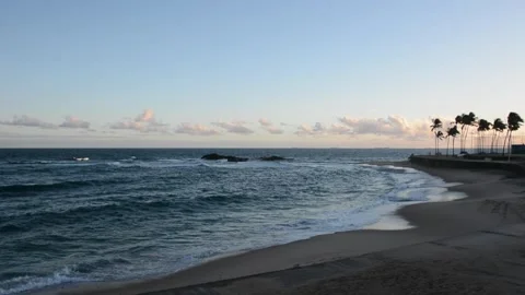 Ocean waves crashing on the beach against a cloudy blue sky. Living nature... Stock Footage 313202525