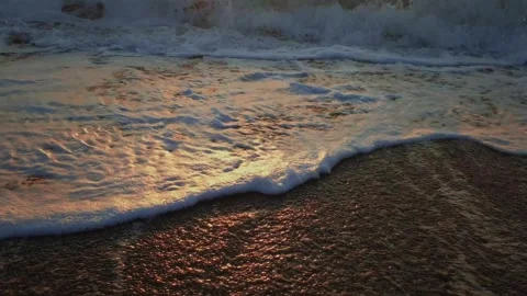 Ocean waves crashing on beach during sunset Stock Footage 318611864