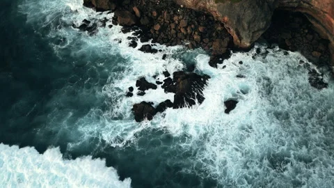 Ocean waves crashing into big rocks during sunset Stock Footage 250070106