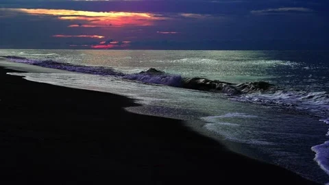 Ocean waves crashing on dark sand beach during sunrise Stock Footage 341361056