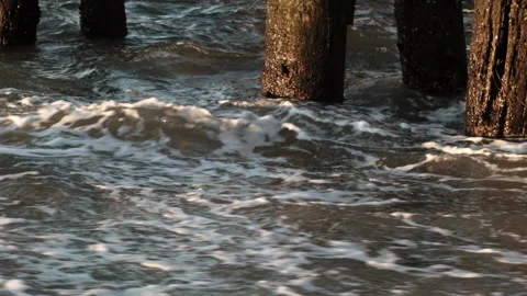 Ocean Waves Crashing over Posts at Sunset Stock Footage 185095515