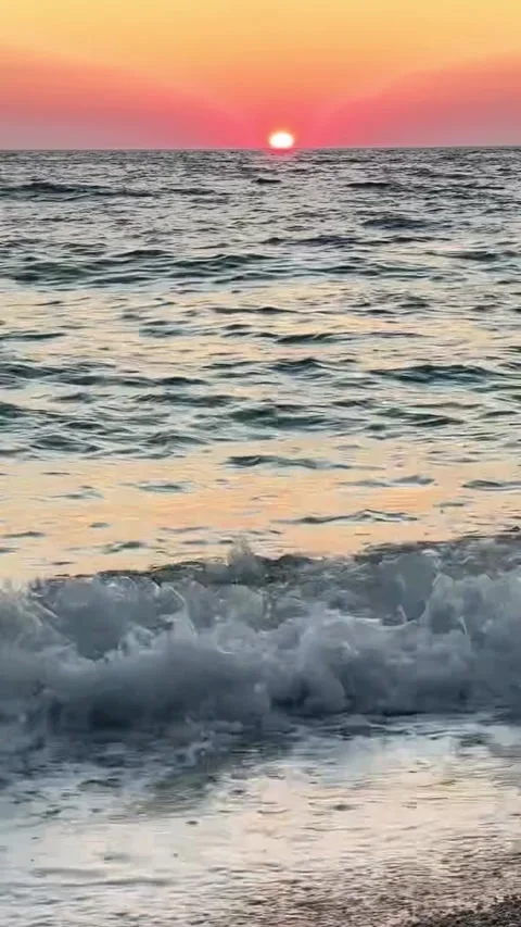 Ocean Waves Crashing on Pebble Beach at Vibrant Sunset Stock Footage 339880843