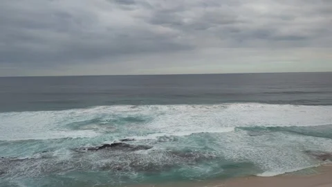 Ocean waves crashing on a rock pool and then onto the beach. 库存影片 277601361