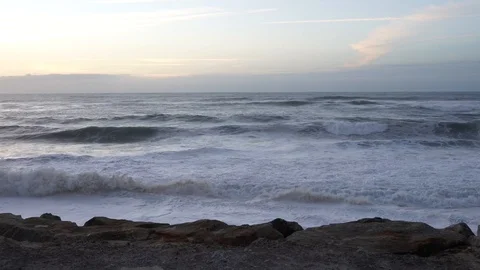 Ocean waves crashing on rocks close to the shore, late in a summer day. In Stock Footage 107564621