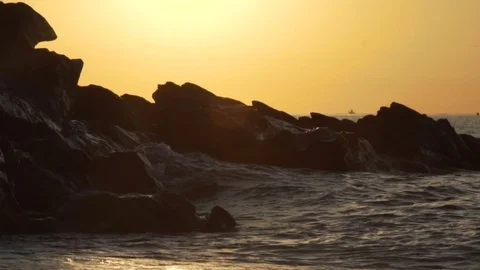 Ocean waves crashing onto the rocks in the sunset. 120fps Stock Footage 81765331