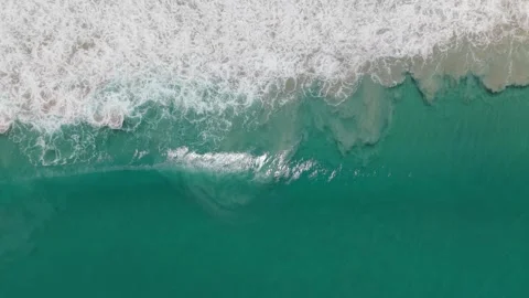 Ocean waves crashing on sandy beach, turquoise water and white foam Stock Footage 336927081