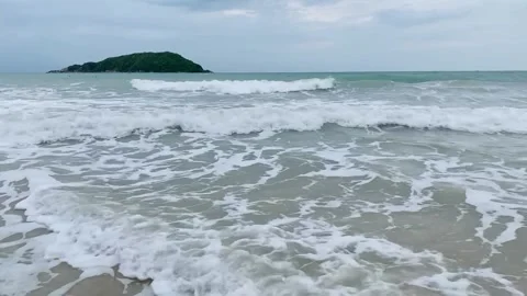 Ocean Waves Crashing onto Sandy Beach with Island in Background Stock Footage 339527495
