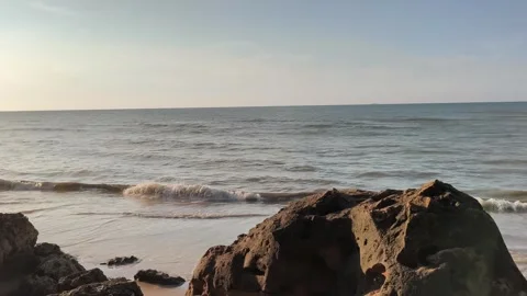 Ocean Waves Crashing on Sandy Beach with Jagged Rocks Video stock 340489584