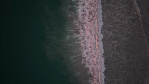 Ocean waves crashing onto sandy beach at dusk, aerial view of shoreline Vídeos de archivo 342332657