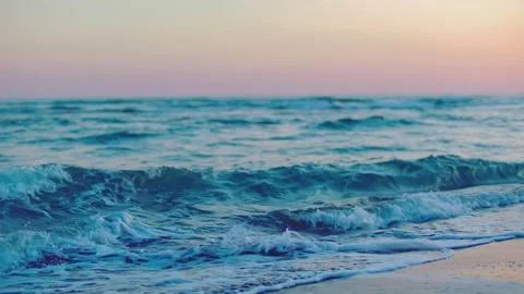 Ocean waves crashing on sandy beach shore during sunset for relaxing travel Stock Footage 345483886
