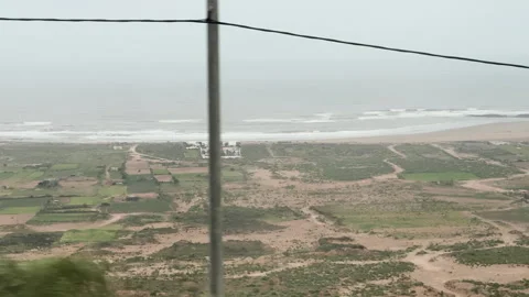 Ocean waves crashing on the shore next to a construction site at Morocco Видео 332763836
