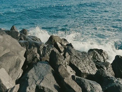Ocean waves crashing on stone beach Vídeos de archivo 71053543