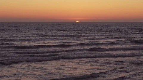 Ocean waves crashing at sunset in the Pacific ocean. Sun slowly disappearing. Video stock 88629616
