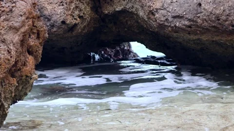 Ocean waves crashing under a rock formation in Oahu Hawaii Stock Footage 279909861