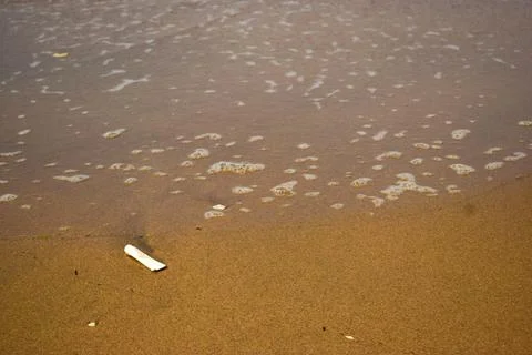 Ocean Waves Creating Foamy Patterns Along a Sandy Beach Shore Stock Photos