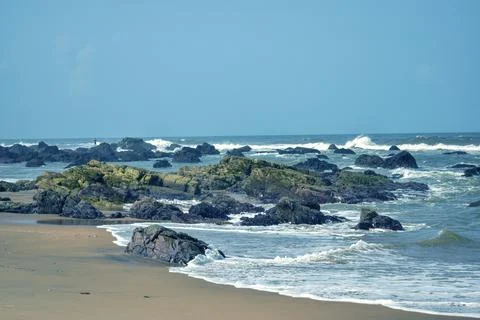 Ocean Waves Creating Foamy Patterns Along a Sandy Beach Shore Fotos Stock