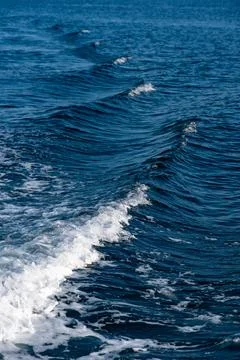 Ocean waves creating white foam on deep blue water Stock Photos