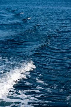 Ocean waves creating white foam on deep blue water Stock Photos