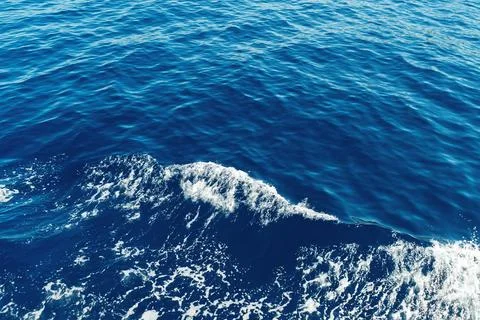 Ocean waves with deep blue water creating white foam Stock Photos