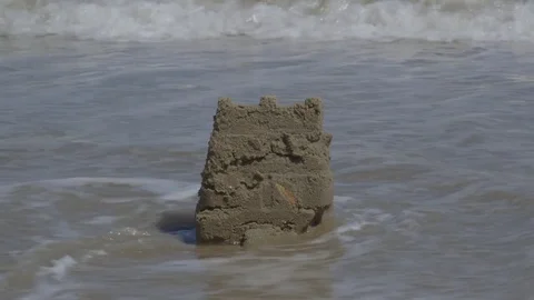 Ocean Waves Destroying Sandcastle on the Beach Stock Footage 74386868