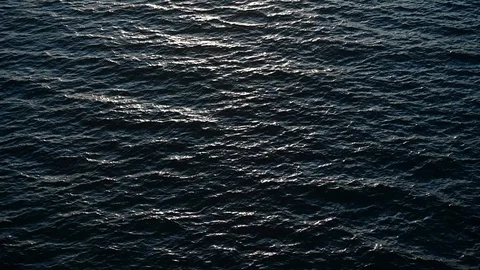 Ocean waves during sunset. Sun glitters on a water surface. Stock Footage 128901235