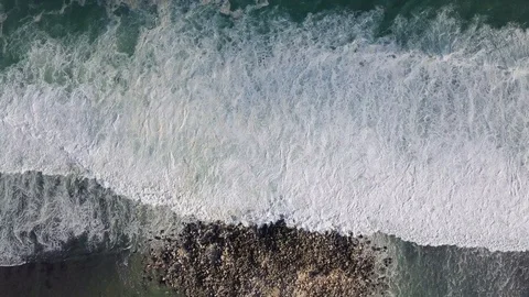 Ocean waves with foam roll on the shore, aerial view. Video stock 116184554
