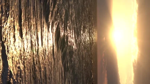 Ocean waves with foam on sandy beach and beautiful golden sunset in sky. Video stock 240198098