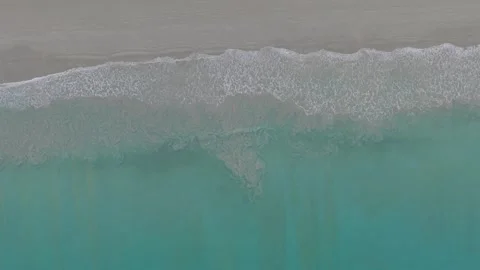 Ocean waves gently rolling onto sandy beach, aerial view of shoreline Vídeos de archivo 337417964