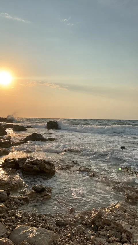 Ocean waves gently rolling onto the shore at sunset Stock Footage 304879397