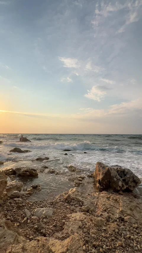 Ocean waves gently rolling onto the shore at sunset Stock Footage 304879406