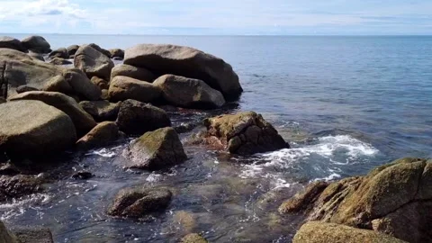 Ocean waves gently washing over rocks 스톡 동영상 222003646