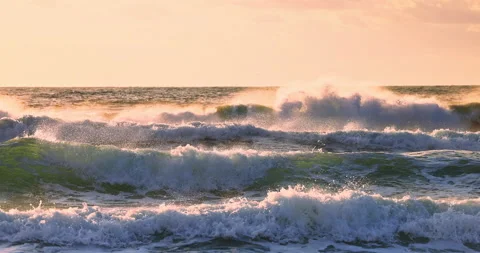 Ocean waves at golden sunrise light rolling toward beach sand Stock Footage 344738882