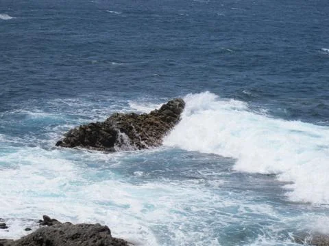Ocean waves hitting a rock Stock Photos