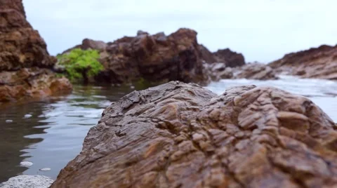 Ocean waves hitting rocks   side pool beach Stock Footage 66557372