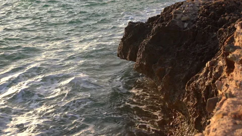 Ocean waves hitting the rocks at sunset. View from the rocks. 스톡 동영상 131858028